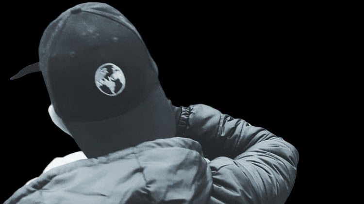 Person wearing a cap with a logo on a black background